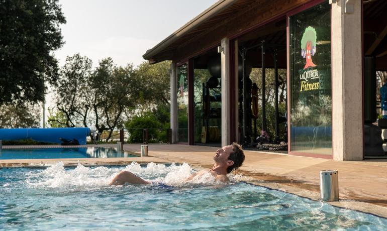 Entspannter Mann im Pool nahe Fitnesscenter.