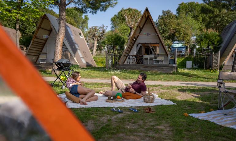 Entspanntes Paar beim Camping nahe A-Rahmen-Hütten.