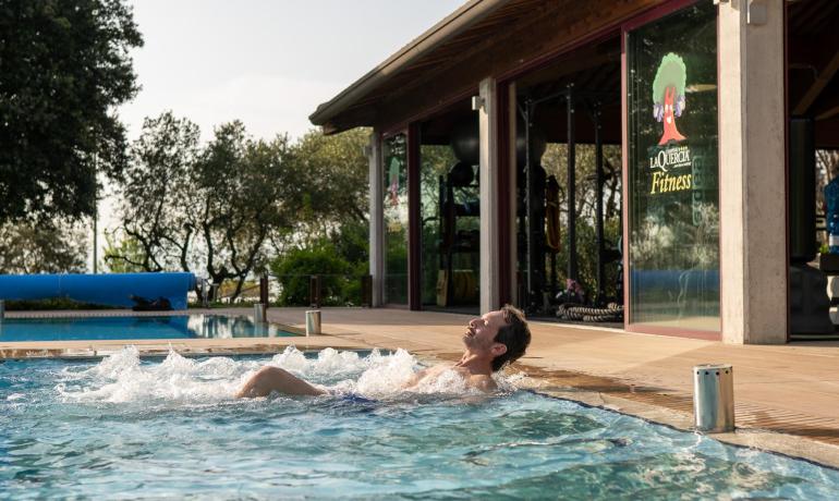 Uomo rilassato in piscina vicino a palestra.